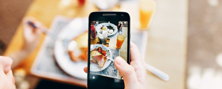 person taking a picture of their breakfast with their phone