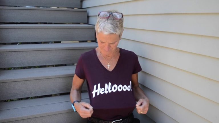 woman looking down a the tshirt she is wearing with the phrase helloooo! printed on it