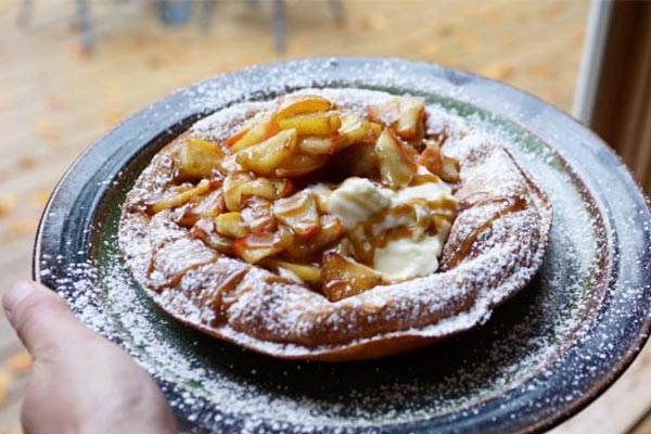 Dutch baby breakfast pastry filled with fruit and topped with powdered sugar