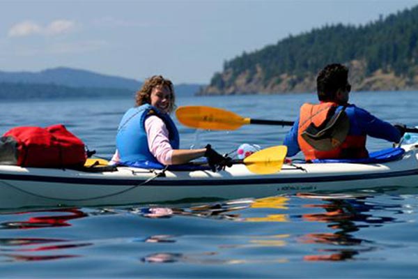 kayakers with one woman turned and smiling at the camera