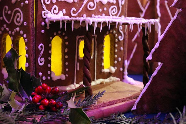 detailed view of a gingerbread house porch with icing icicles and candy windows