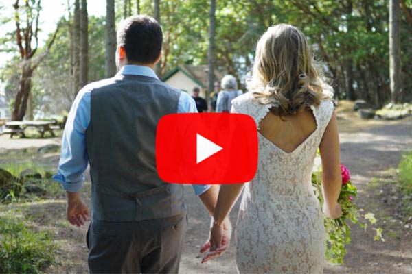 Bridal couple walking down a wooded path viewed from behind